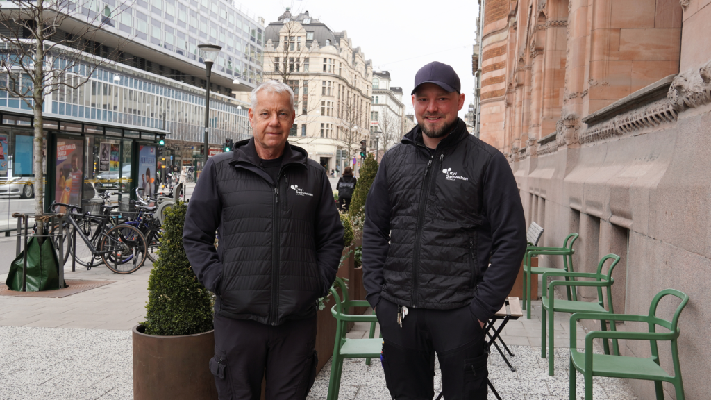 Två leende män står med händerna i fickorna på Vasagatan i Stockholm.