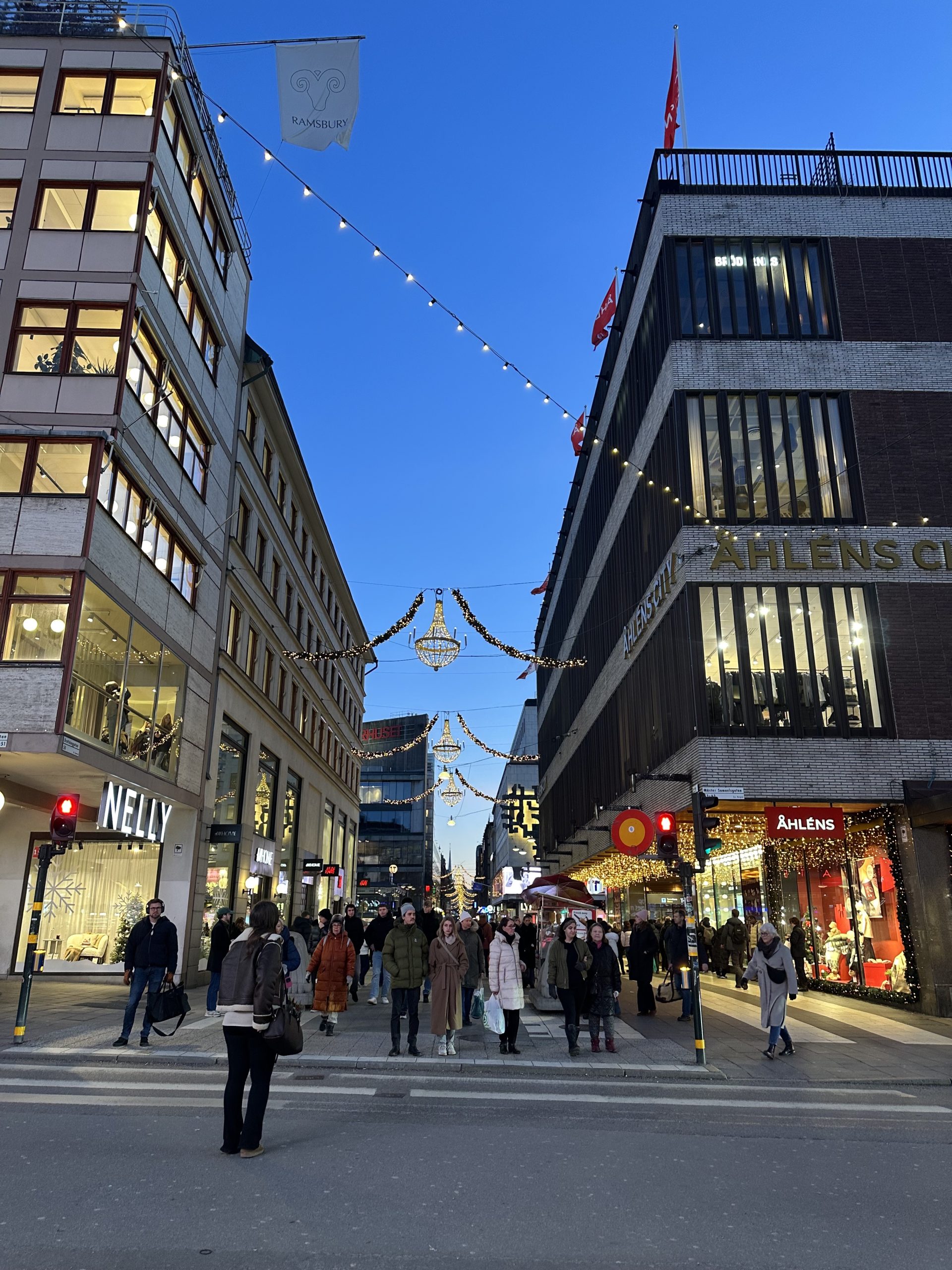 Belyst gata i Stockholm city med många människor